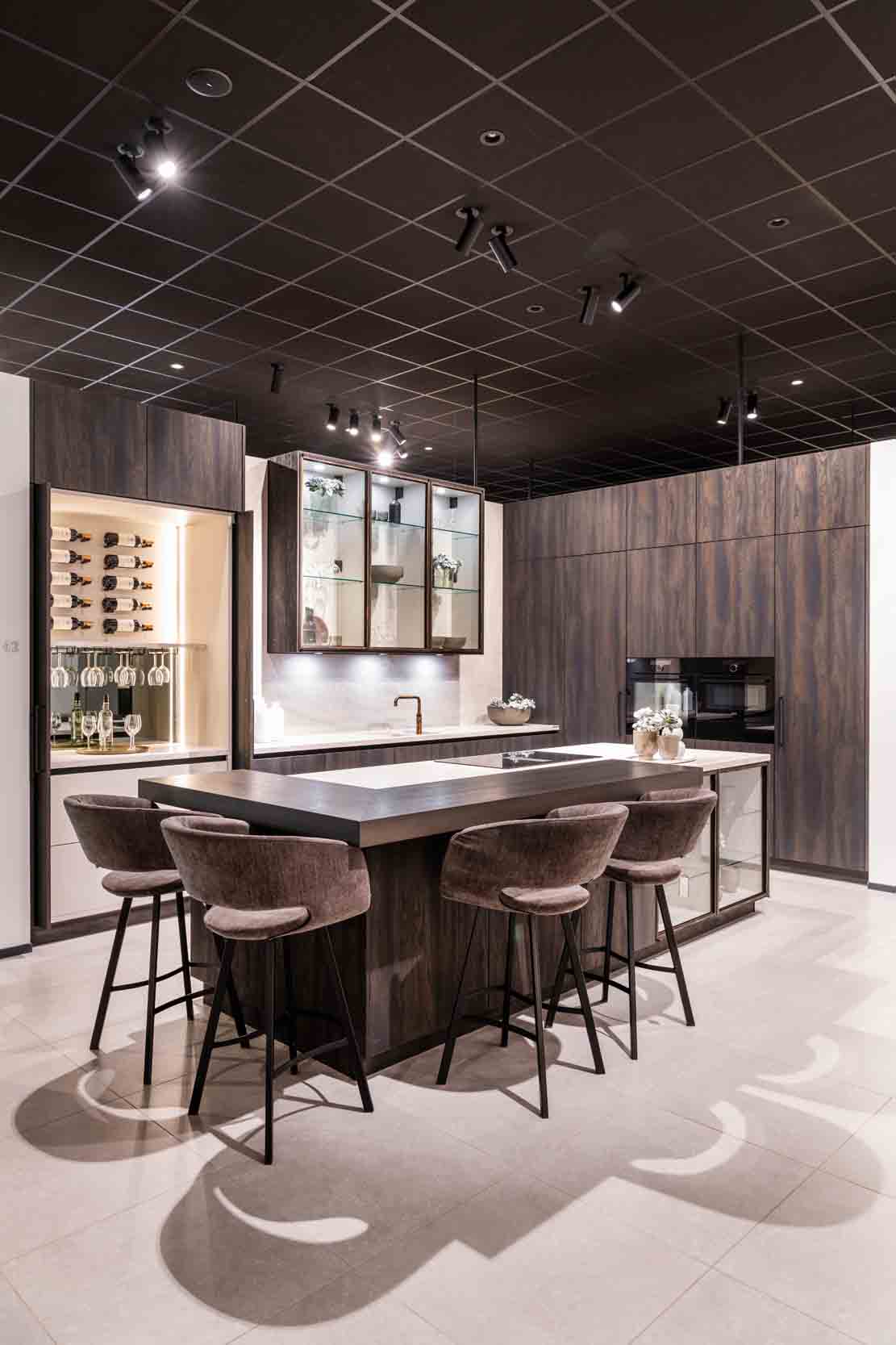 Cuisine sombre avec îlot avec bar et cabinet de dégustation intégré