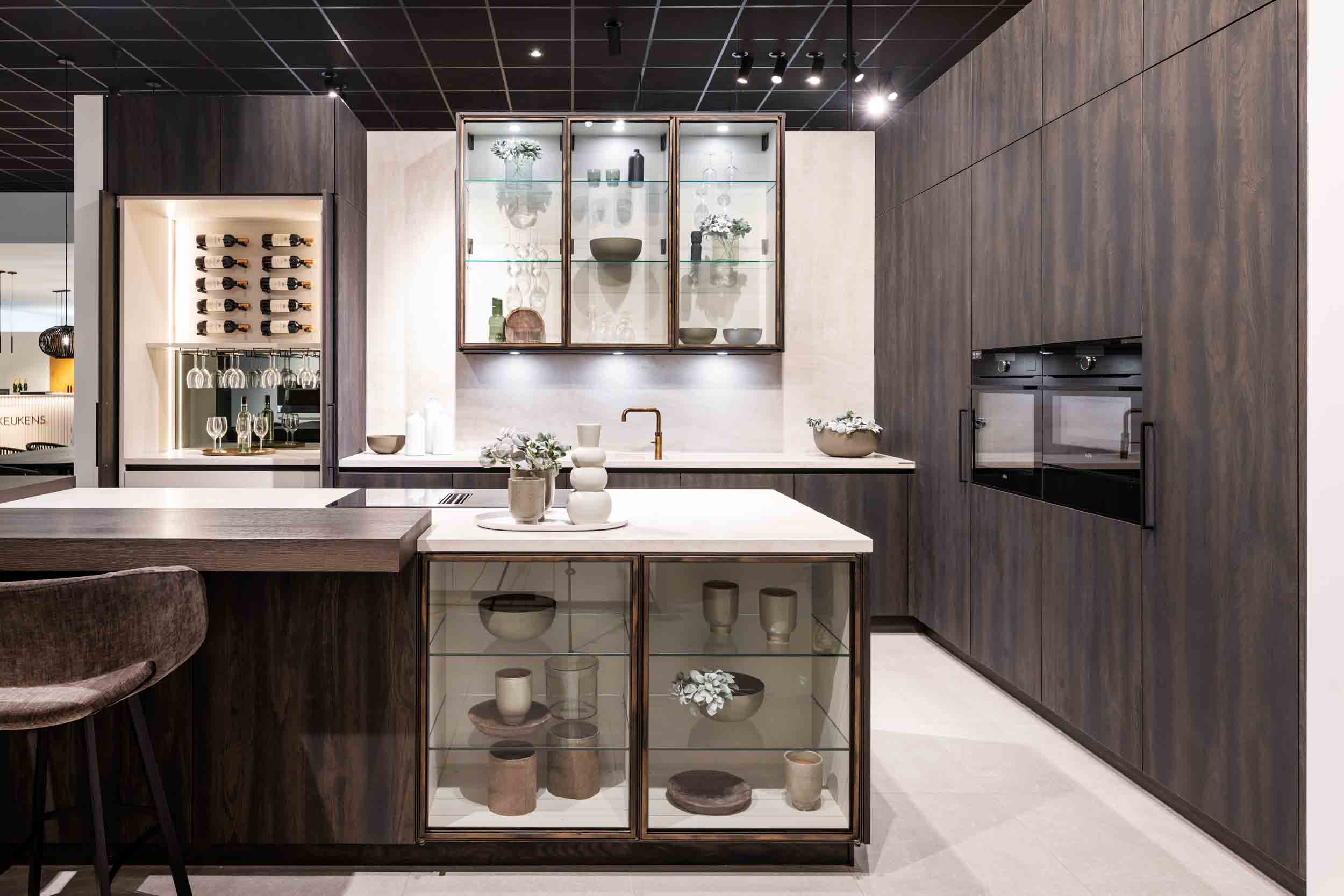Cuisine sombre avec îlot avec bar et cabinet de dégustation intégré